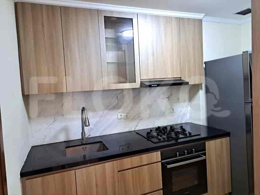 Modern kitchen with wooden cabinets and black countertops.