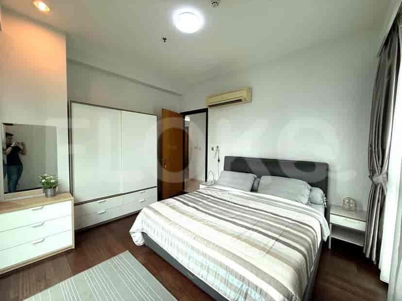 A bedroom with a bed, a large wardrobe, and wooden flooring.