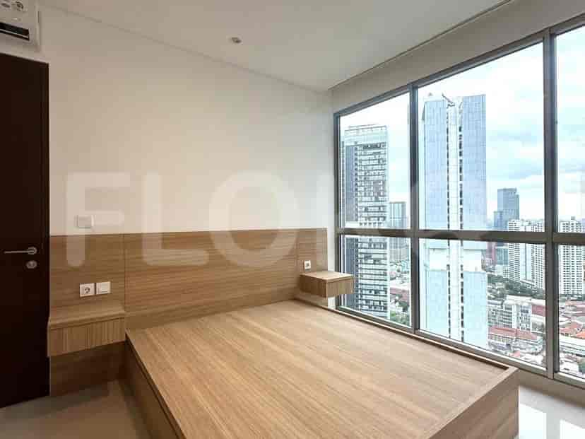 Bedroom with a wooden bed frame, built-in bedside tables and large windows.