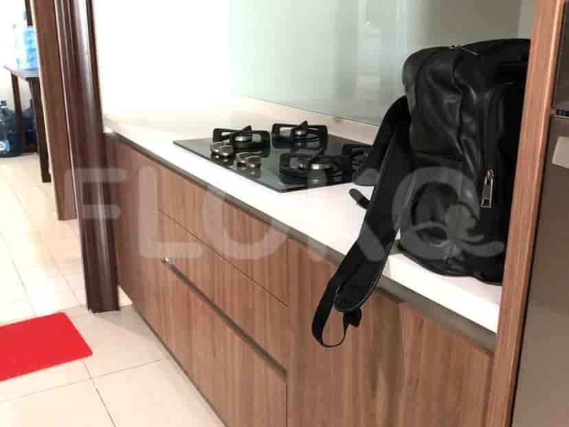 Dapur modern dengan kompor kaca, lemari kayu, dan meja putih.