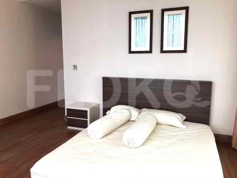 Kamar tidur dengan tempat tidur, nakas, dan dua jendela kecil.