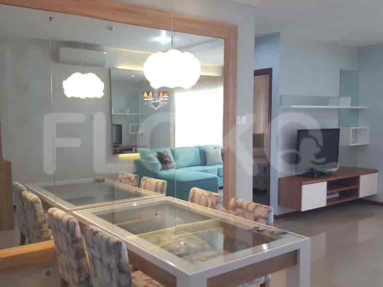 Spacious dining area and living room with large mirror, dining table with chairs, and turquoise sofa.