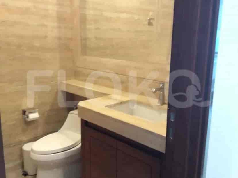 A bathroom with a vanity, toilet, and tiled walls.