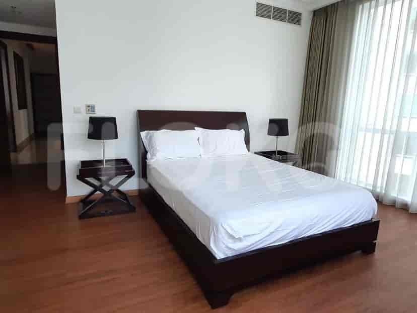 Kamar tidur utama dengan tempat tidur ganda, meja samping tempat tidur, dan lampu.