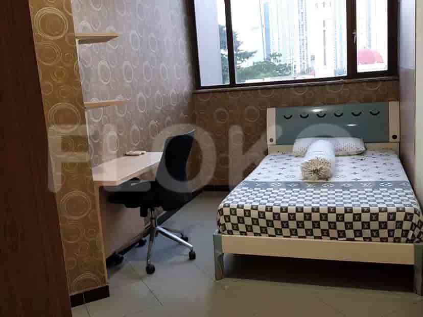 A cozy bedroom with a bed, desk, and wallpaper.