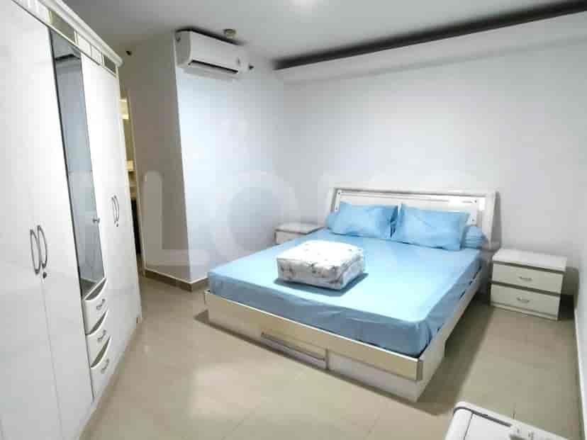 A well-lit bedroom with a bed, wardrobes, and a window.