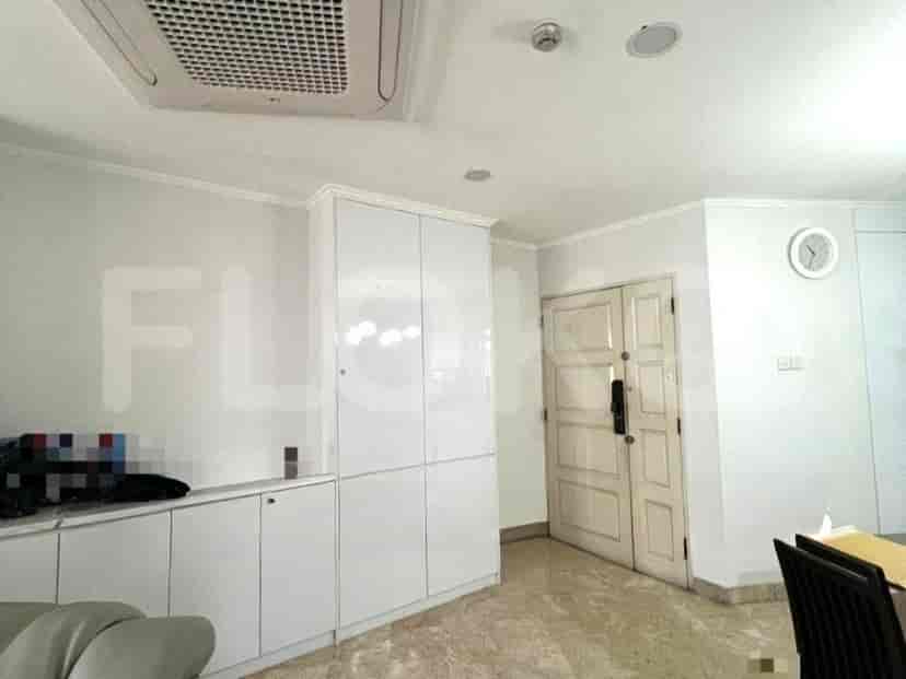 A living room with white cabinets, a door, and a clock.