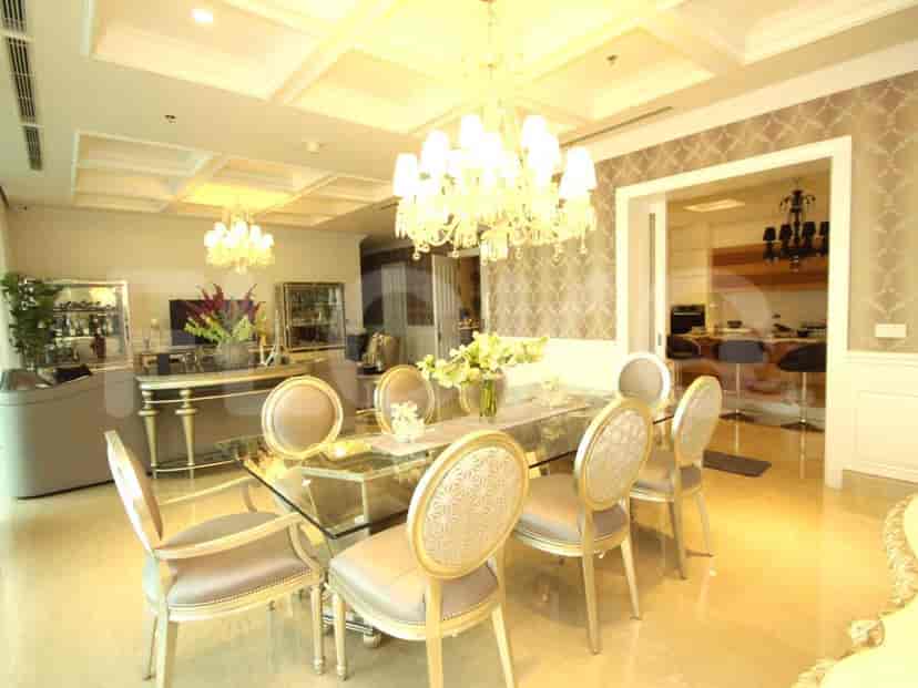 A formal dining room with a glass table and seating.