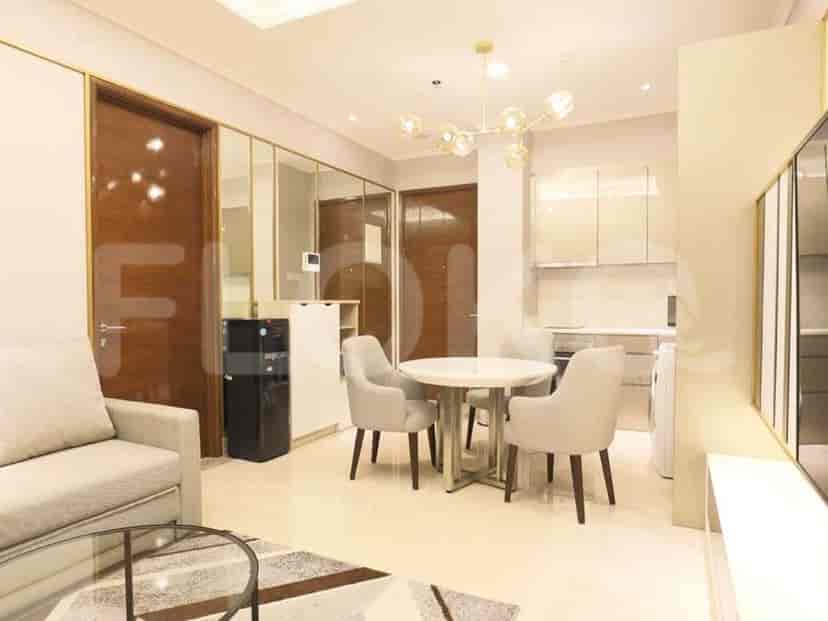 Living room showing dining area, sofa, and door to other rooms.
