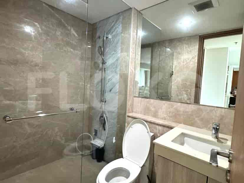 A modern bathroom with marble walls and a glass shower.