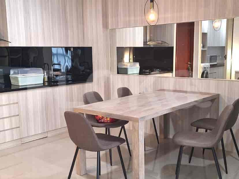 Modern kitchen and dining area with wooden accents and integrated appliances.