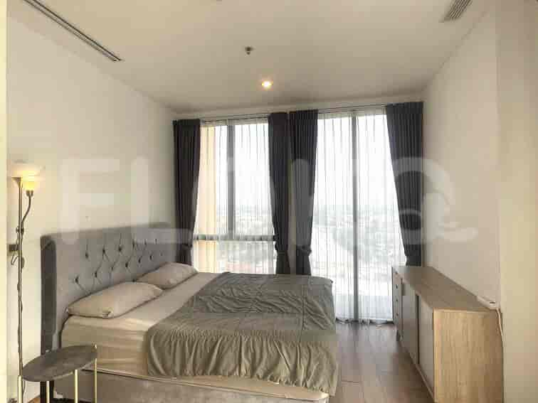 Kamar tidur yang menampilkan tempat tidur besar, lemari, dan jendela besar dengan gorden.