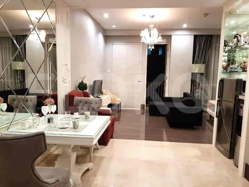 Luxurious living and dining area with a large dining table, mirrors, and a view of the living area.