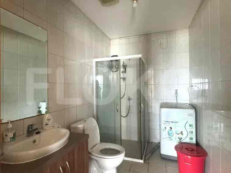 Functional bathroom with a washing machine and a shower.
