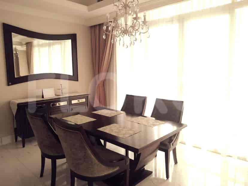 A dining room with a wooden table and chairs.