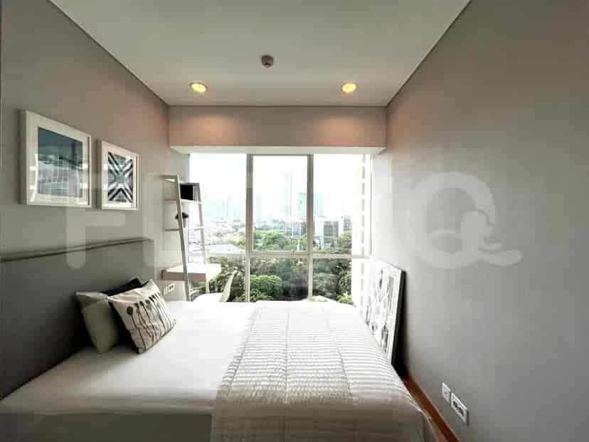 Bedroom with a bed, window, and artwork.
