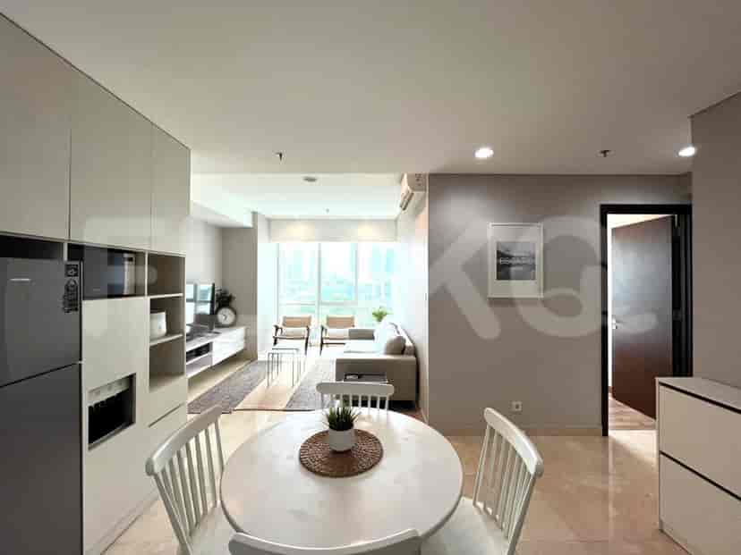 Open-plan living and dining area with a sofa, kitchen, and dining table.