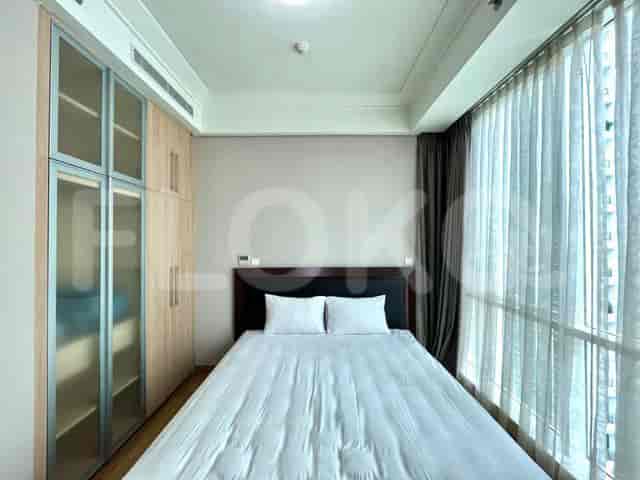 Bedroom with a bed, wardrobe, and large windows.