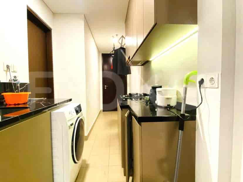 Tata letak dapur modern dengan meja dapur berwarna gelap, lemari kayu, dan mesin cuci.