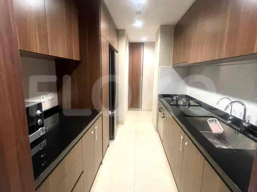 A galley kitchen with wooden cabinets, a black countertop, and modern appliances.