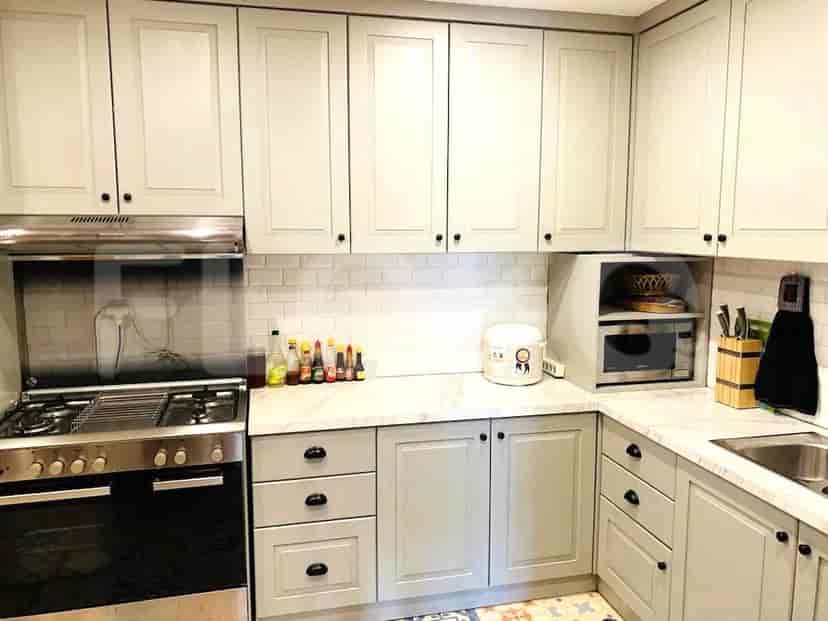 A modern kitchen with light gray cabinets, a gas stove, and a microwave.