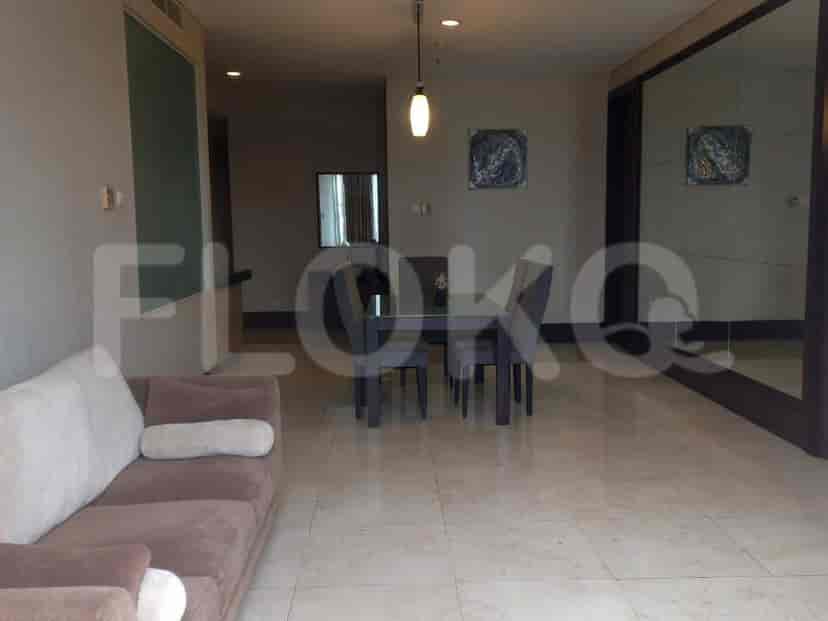 A living and dining area with a sofa, dining table, and a large mirrored wall.