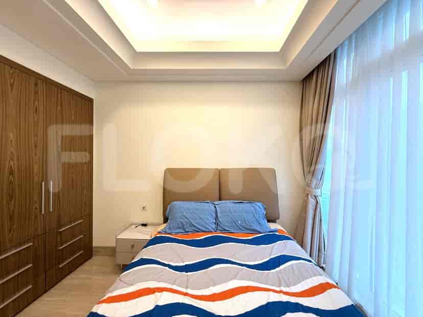 A bedroom with a queen-sized bed, a wardrobe, and a nightstand.