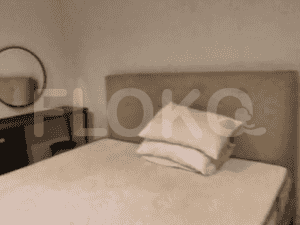 A bedroom with a bed, a mirror and a small table.