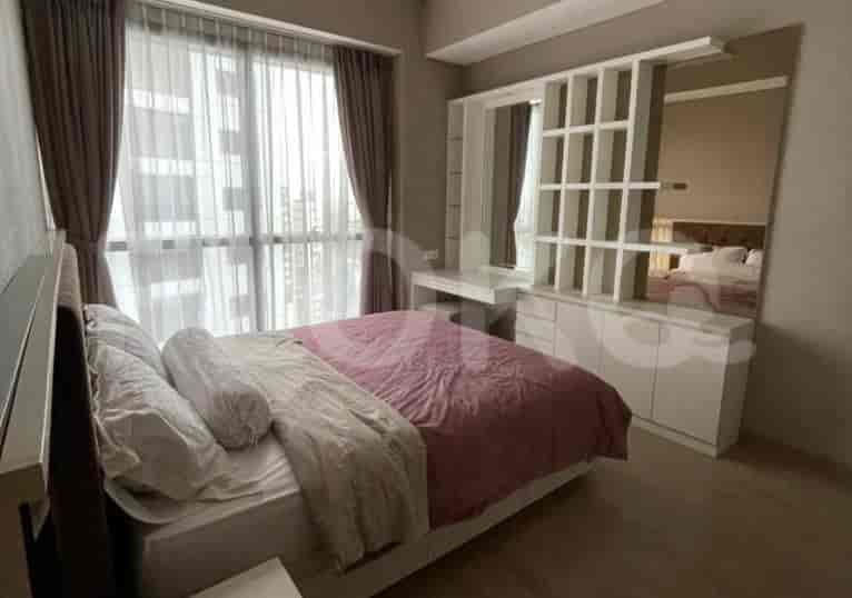 Bedroom with a double bed, built-in storage, and large windows.