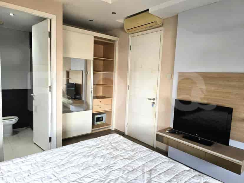 Kamar tidur utama dengan lemari pakaian, TV, dan akses kamar mandi.