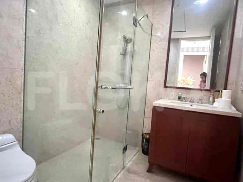A modern bathroom with a glass-enclosed shower, marble accents, and a vanity with a mirror.