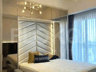 A modern bedroom with a large bed and a headboard with mirrors.
