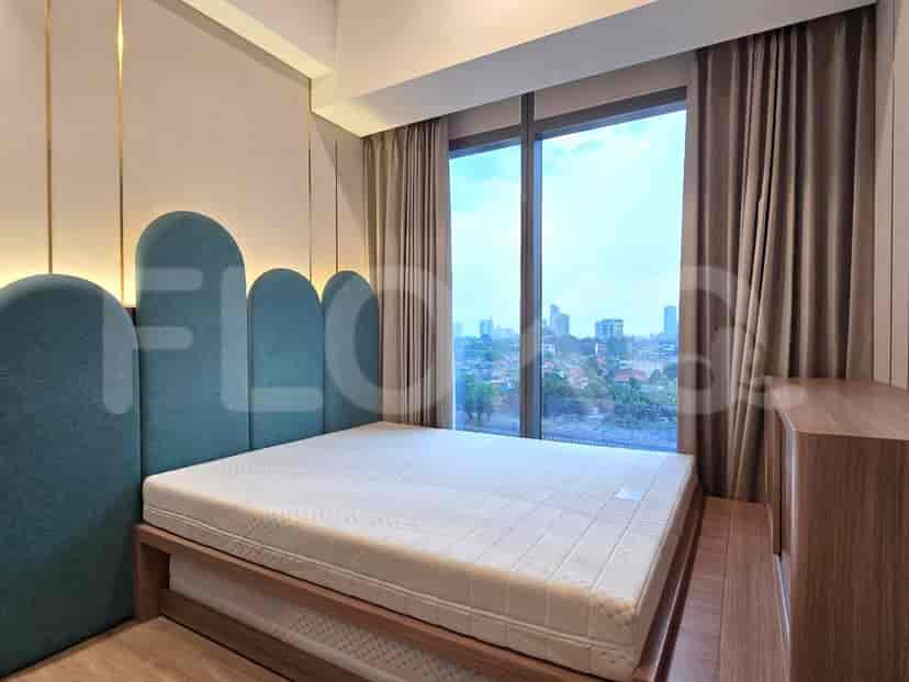 Bedroom featuring a queen-sized bed, a large window, and a built-in wardrobe.