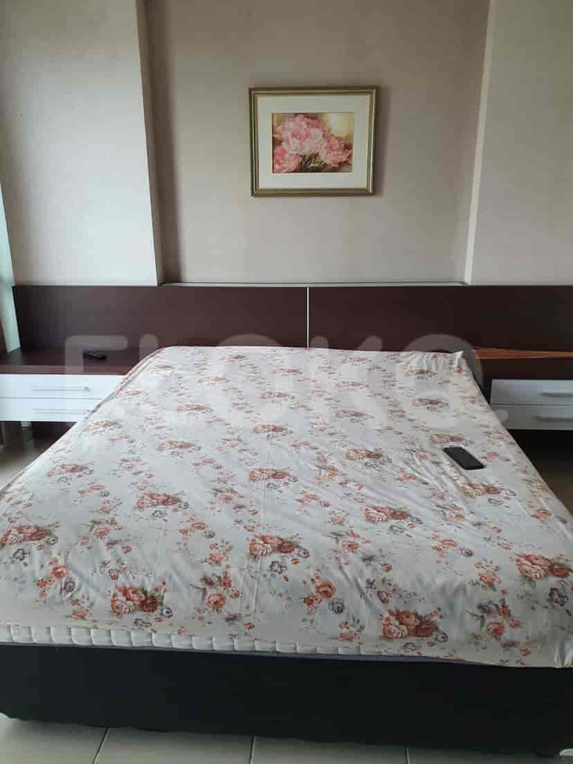 Close-up of a bedroom with a bed and a painting.
