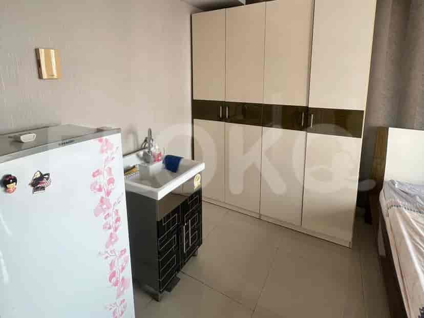 Kitchenette with a sink, refrigerator, and cabinets.
