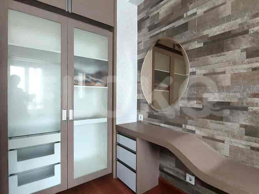 Vanity area with a curved wooden desk, round mirror, and large wardrobe.