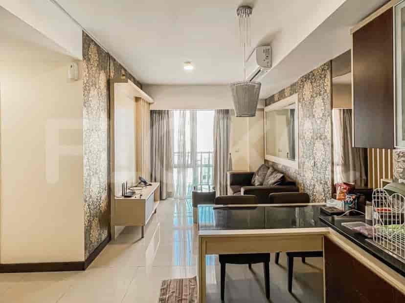 Living room and kitchen with a dining area and city view.