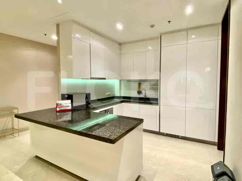 A modern kitchen with a central island and sleek white cabinets.