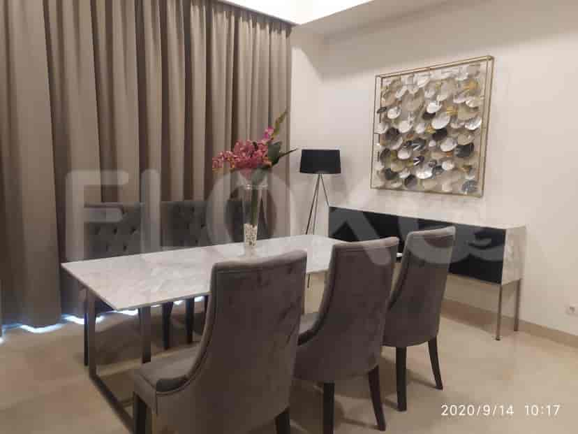 An elegant dining area with a marble-top table and grey chairs.