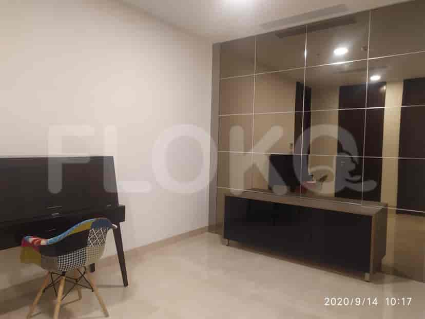 A room with a mirrored wall, desk, and storage unit.