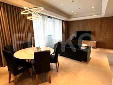 Modern living room with a round dining table, black chairs, and an overhead light fixture.