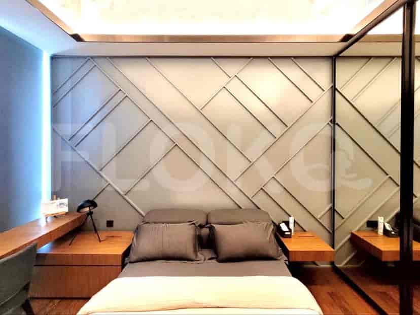 A modern bedroom featuring a bed, bedside tables, and a workspace.
