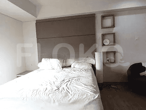 A bedroom with a bed, wall decorations, and a neutral color scheme.