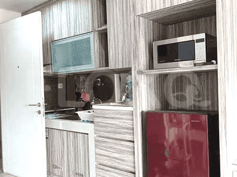 An enclosed kitchen with a microwave, and a mini-refrigerator.