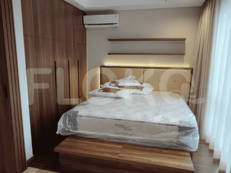 A bedroom with a bed, wooden furniture, and an air conditioner.
