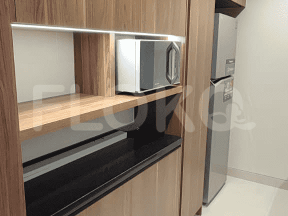 A kitchenette with a microwave, refrigerator, and cabinetry.