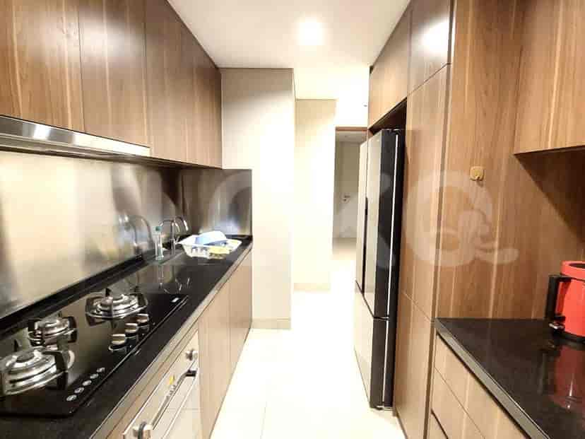 Modern kitchen with wooden cabinets and stainless steel backsplash.