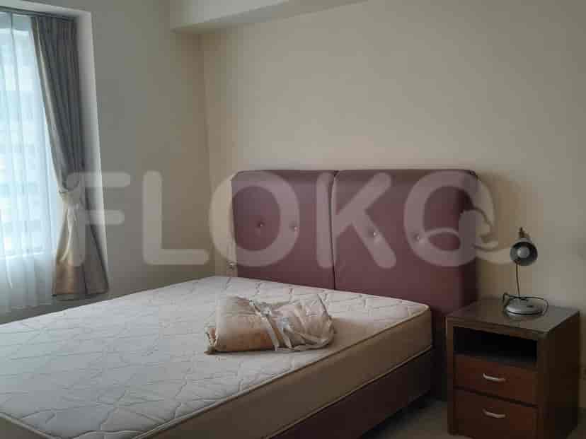 Kamar tidur dengan tempat tidur ganda dan meja samping tempat tidur.