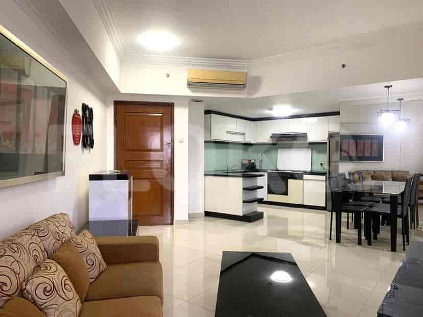 Combined living room and kitchen with a dining table and a view of the kitchen with cabinets.