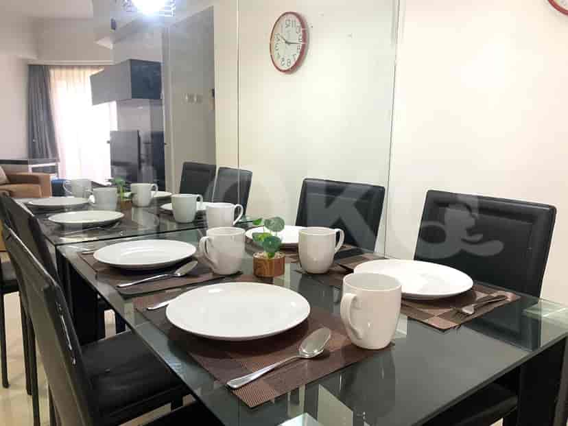 Dining table set with plates, mugs, and silverware, ready for a meal.